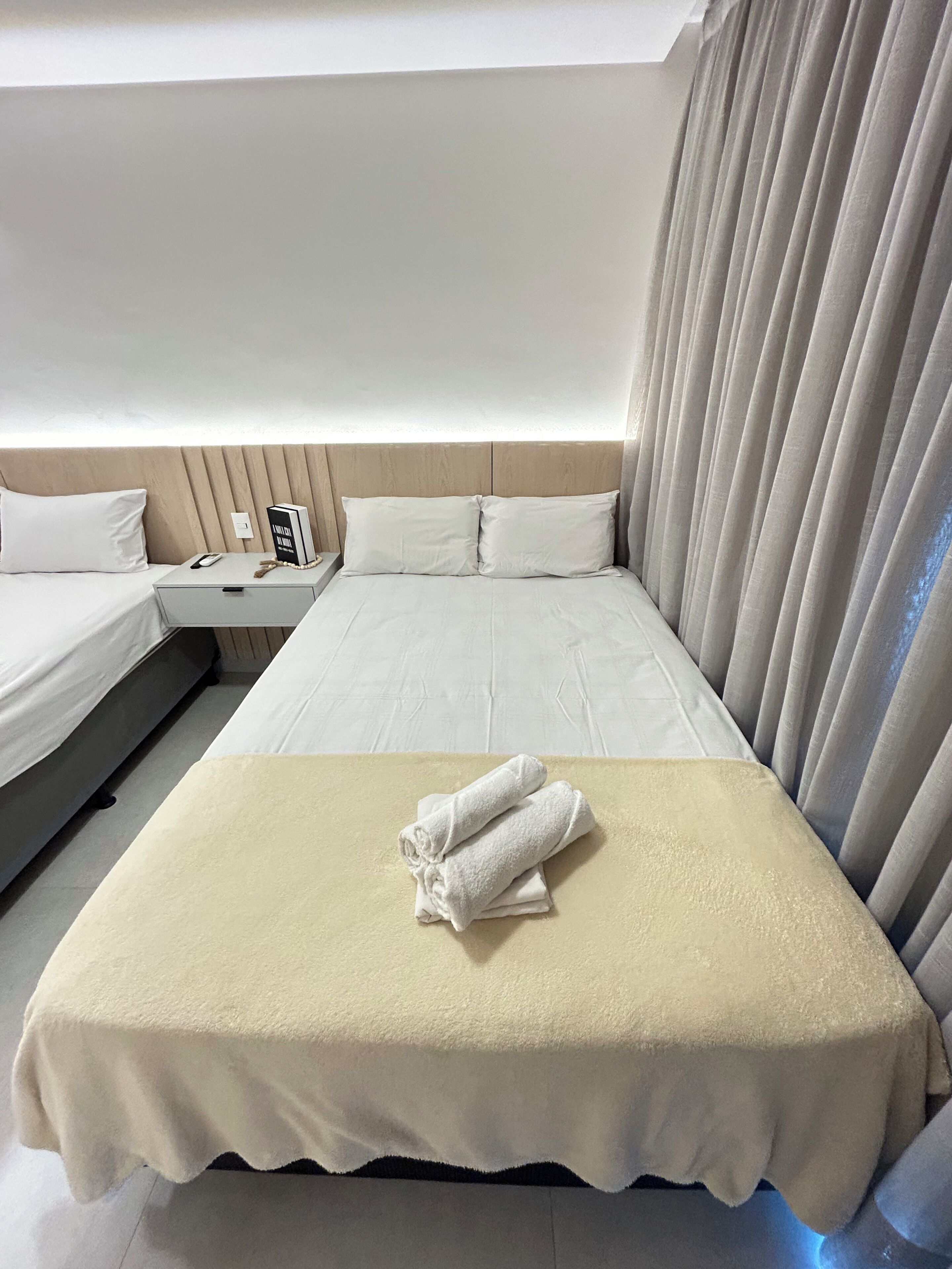 Ein Hotelzimmer mit einem Bett, einem Nachttisch mit einem Buch und einem Beistelltisch.