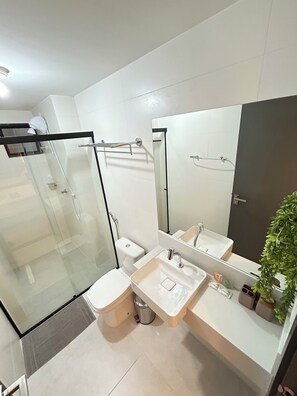 Apartamento | Banheiro | Chuveiro, secador de cabelo, toalhas de banho, papel higiênico