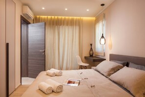 A modern hotel room with a large bed, a desk, a chair, and a mirror. - Villa Royal Green, Labin, Croatia (Labin)