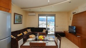 A modern living room with a dining table, sofa, and TV. - Holiday Apartment Central & Sea View, Vlore, Albania (Vlore)