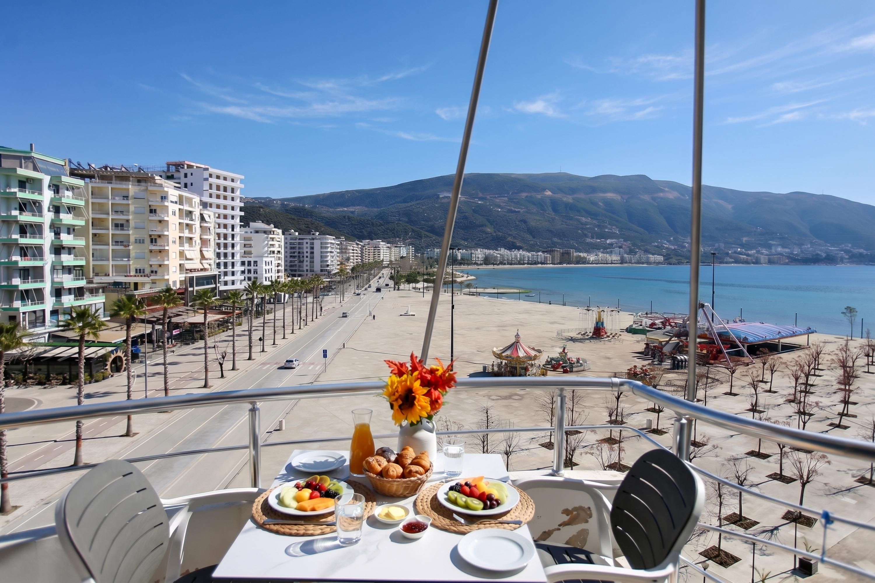 Ein Tisch mit Frühstück, mit Blick auf Strand und Stadtlandschaft.