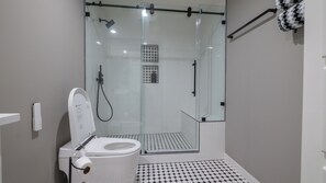A modern bathroom with a glass-enclosed shower, a toilet, and a patterned floor. - Completely Remodeled, Perfect for the World Cup (Dallas)