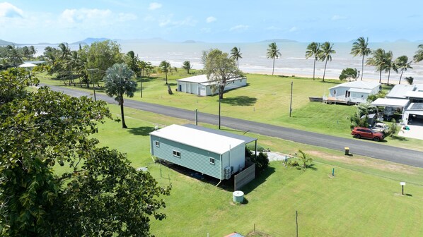 A residential area with a road, houses, and a view of the ocean.