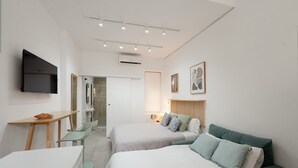 A modern hotel room with two beds, a desk, a TV, and a bathroom. - Baélia Casa Íbera Mini Apartment - Altamare (Alicante/Alacant)
