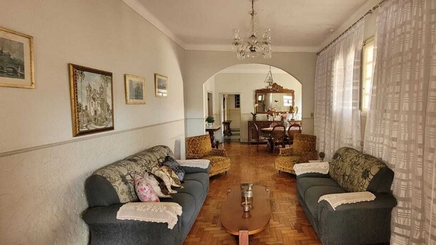 Uma sala de estar com dois sofás, uma mesa de centro e um candelabro.