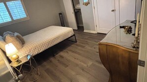 Et soveværelse med seng, loftsvifte, kommode og walk-in closet.