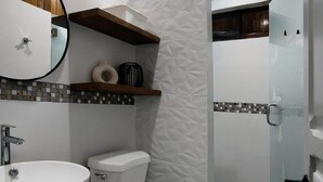 A bathroom with a white sink, toilet, and shower.