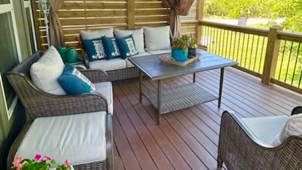 A covered outdoor seating area with wicker furniture, a table, and a potted plant. - Luxury Golf Course Chalet Near World Cup Matches Airport and Legends, Sleeps 6+ (Basehor)