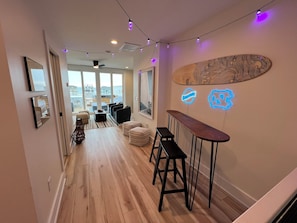Ein modernes Interieur mit Holzboden, einer Bar und Blick durch große Fenster.