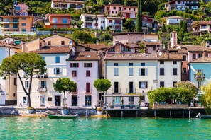 A coastal town with colorful buildings, a marina, and a clear view of the water. - Palazzo Gritti Lavanda, Morcote, Switzerland (Morcote)