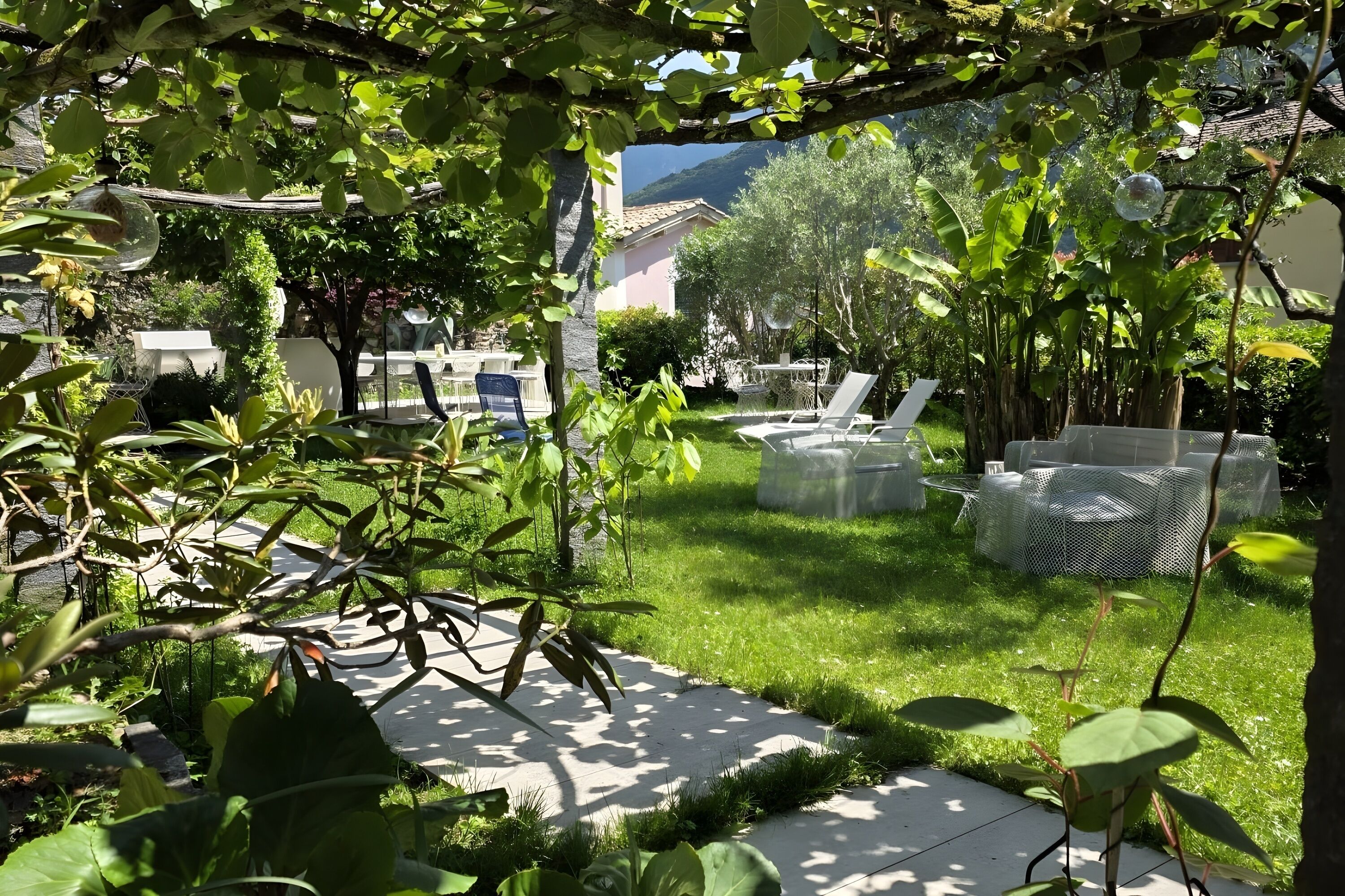 Ein Garten mit Terrasse, Gartenmöbeln und Bergblick.