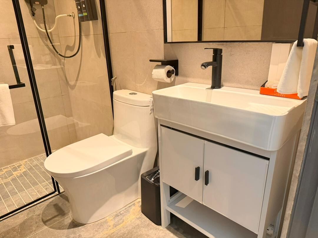 A modern bathroom with a toilet, sink, and shower.