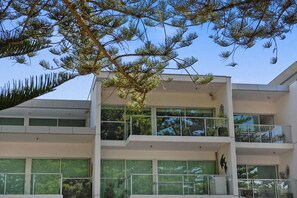 Un immeuble moderne à plusieurs étages, doté de grandes fenêtres et de balcons.