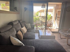 Ein Wohnzimmer mit einer Couch, einem Couchtisch und einem Essbereich mit Stühlen und einem Tisch.