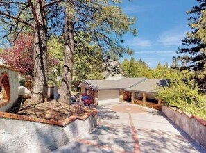 A house with a covered porch, a stone fireplace, and a driveway.
