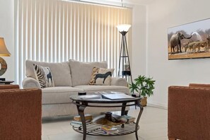 A living room with a sofa, a round coffee table, and two wicker chairs. - Tucson Safari 3/1.5, Crib, Zoo, UofA, Golf, DMAFB (Tucson)