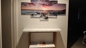 A wall-mounted artwork of a sunset over a rocky beach. - Airport  3-bedroom villa with AC in charming High Wycombe (High Wycombe)