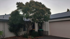 A residential building with a garage, a tree, and a small garden area. - Airport  3-bedroom villa with AC in charming High Wycombe (High Wycombe)