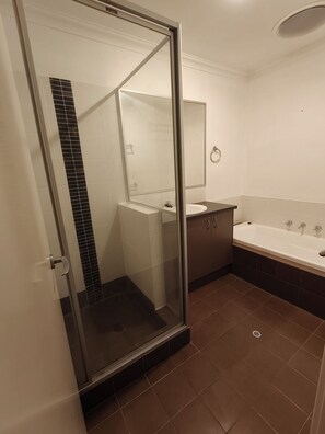 A bathroom with a glass shower enclosure, a white sink, a mirror, and a bathtub.