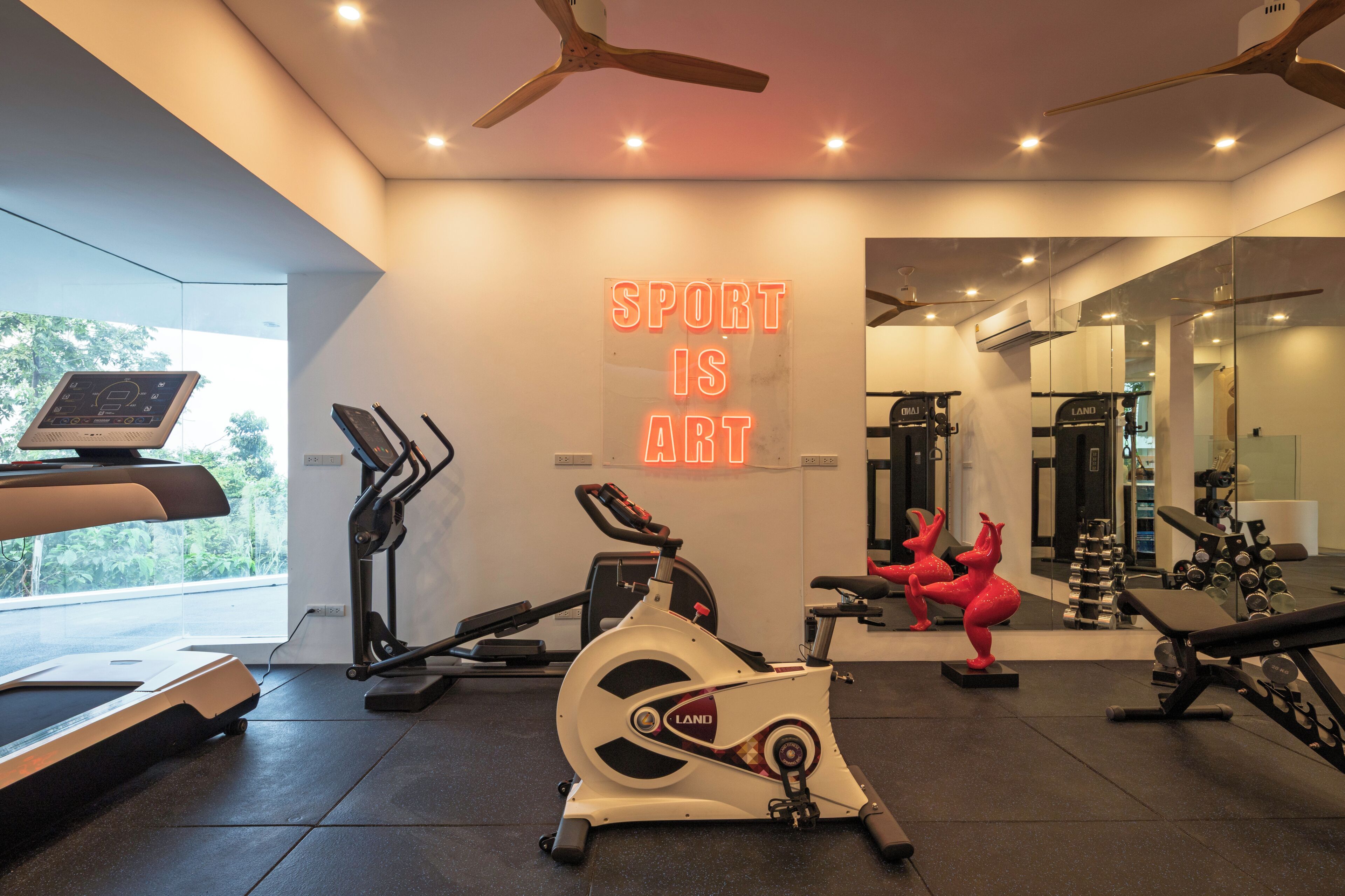 Ein Fitnessstudio mit Trainingsgeräten, Laufband, Crosstrainer und Ergometer, sowie einem motivierenden Spruch.