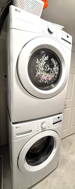 Uma máquina de lavar roupa e secadora empilhadas, com um padrão floral na unidade superior.