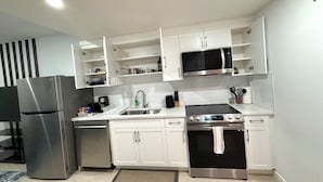 A modern kitchen with white cabinetry, stainless steel appliances, and a tiled backsplash. - Selah’s Suite - (AC+Wifi+3beds(1 King bed +2 twin sofa beds ) (Edmonton)
