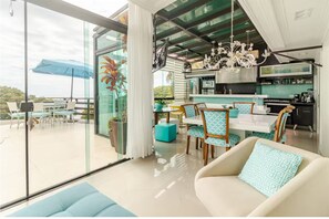 A modern interior with a dining area, kitchen, and a large sliding glass door leading to an outdoor patio.