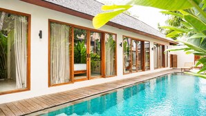 Un moderno resort con piscina, amplias ventanas y terraza de madera.