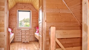 A small, wooden cabin with a loft bed, a window, and a wooden staircase. - Lovely home in Ko1czewo (Ko1czewo)