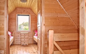 A small, wooden cabin with a loft bed, a window, and a wooden staircase. - Lovely home in Ko1czewo (Ko1czewo)