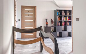 Ein modernes Interieur mit einer Holztür, einer gebogenen Bank und einem Bücherregal voller Bücher.