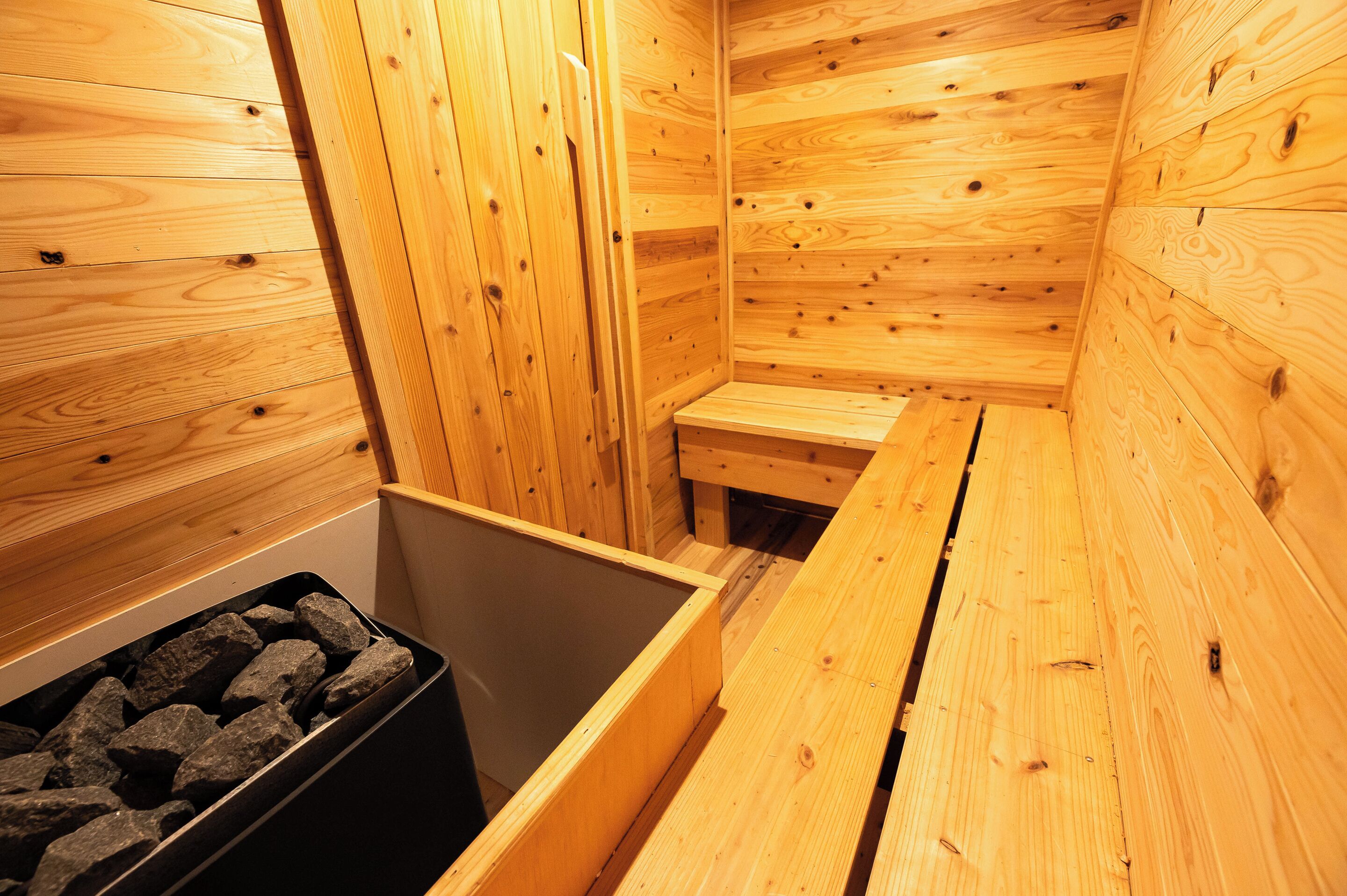 A sauna room with wooden walls and benches.
