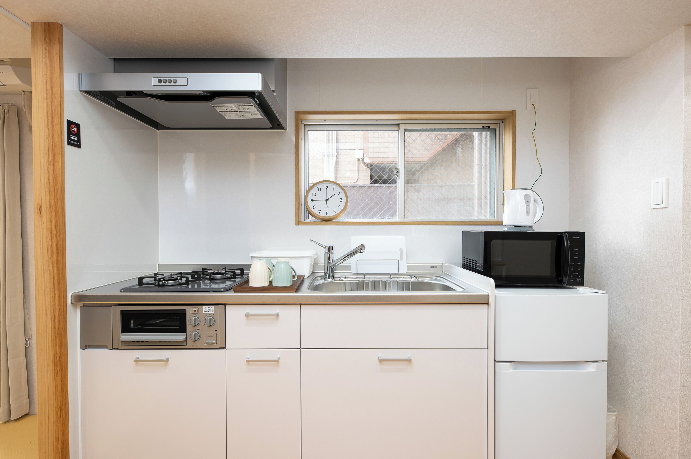 A compact kitchen with a gas stove, microwave, oven, and sink.