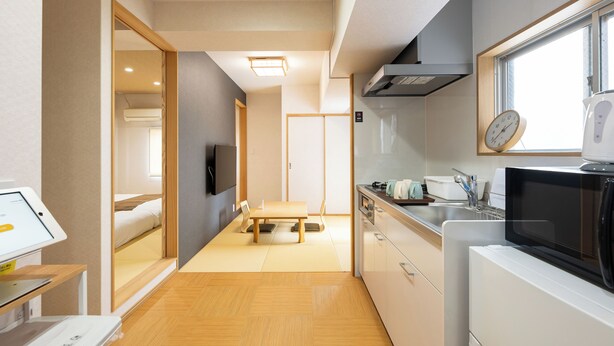 A compact kitchen with a microwave, stove, and sink.