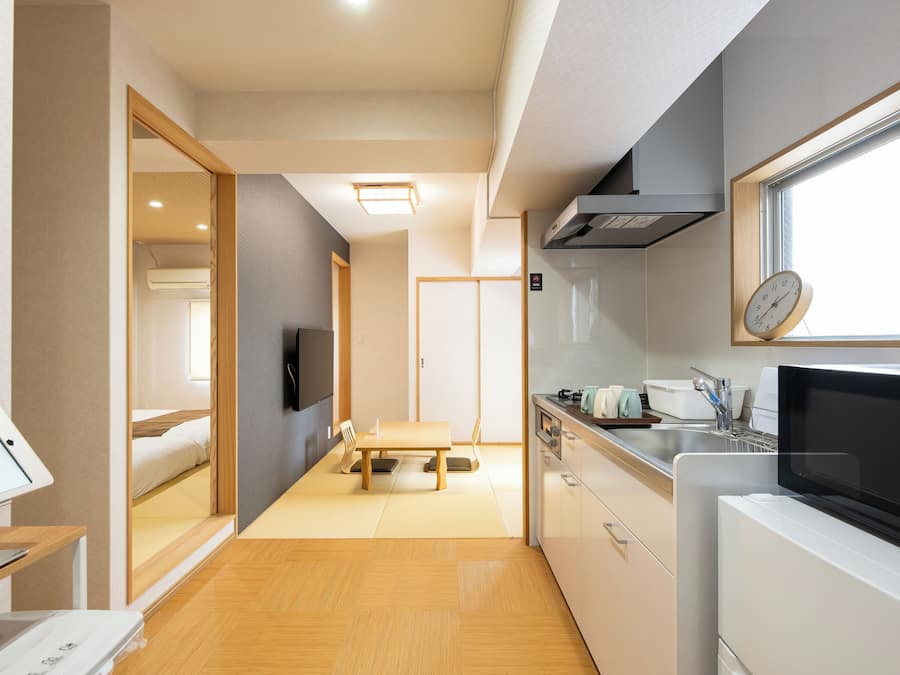 A compact kitchen with a microwave, stove, and sink.