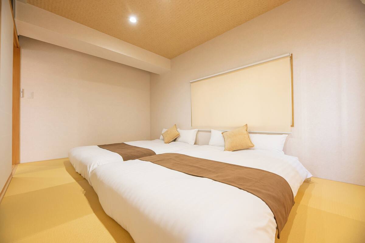 Una habitación de hotel con una cama grande, cabecera y ventana.
