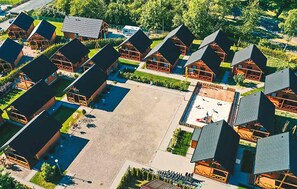 A cluster of cabins with pitched roofs, arranged around a central square with a pool. - Nice home in Rozewie with sauna (Rozewie)