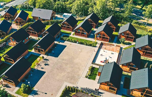 A cluster of cabins with a central open area, surrounded by greenery. - Lovely home in Rozewie with sauna (Rozewie)