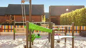 Un parque infantil con columpios, toboganes y estructuras para escalar.