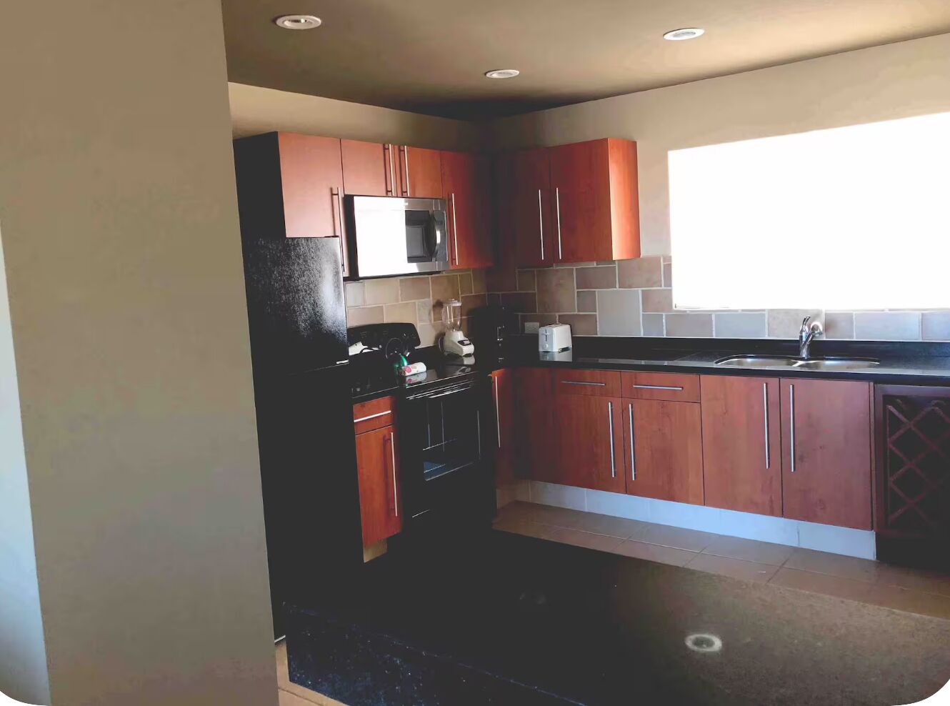 A compact kitchen with a microwave, oven, and sink.