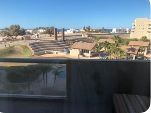 A view of a coastal area with a theater, buildings, and palm trees. - Nice Condo 302 in Las Conchas (Las Conchas)
