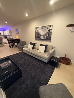 A modern living room with a sofa, coffee table, and a painting on the wall.