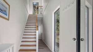 Un escalier menant à un deuxième étage, offrant une vue sur l’extérieur.