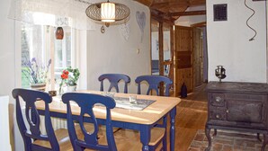 Ein Essbereich mit einem Holztisch, blauen Stühlen und einer Pendelleuchte.