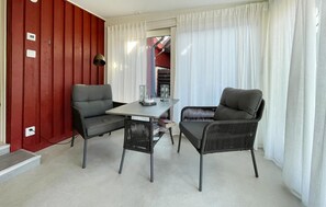 Ein Zimmer mit roter Wand, einem Tisch, zwei Stühlen und einer Lampe.