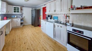 A kitchen with white cabinets, a stainless steel refrigerator, a dishwasher, and an oven.