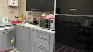 Eine kleine Küche mit Mikrowelle, Toaster und Durchlauferhitzer.