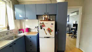 Eine Küche mit Kühlschrank, Spüle und Schränken.