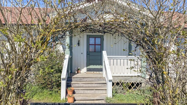 A wooden staircase leading to a white building with a red door, surrounded by greenery. - 3 bedroom stunning home in Mörbylånga (Mörbylånga)