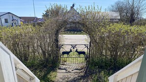 A pathway leading through a gate with deer silhouettes, surrounded by greenery and buildings in the background. - 3 bedroom stunning home in Mörbylånga (Mörbylånga)